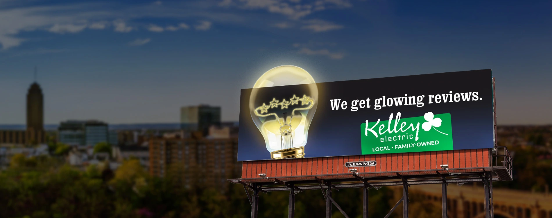 Adams Outdoor Advertising billboard for Kelley Electricity featuring an illuminated bulb extension.