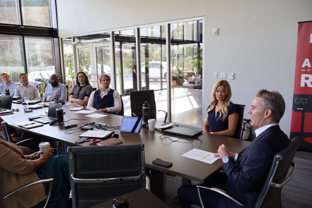 Adams Outdoor Apex Emerging Leaders cohort seated around a conference table during a leadership workshop in Charlotte