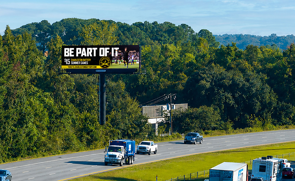 Charleston Battery 'Be Part of It' $15 summer games billboard on an Adams Outdoor digital billboard beside a Charleston highway